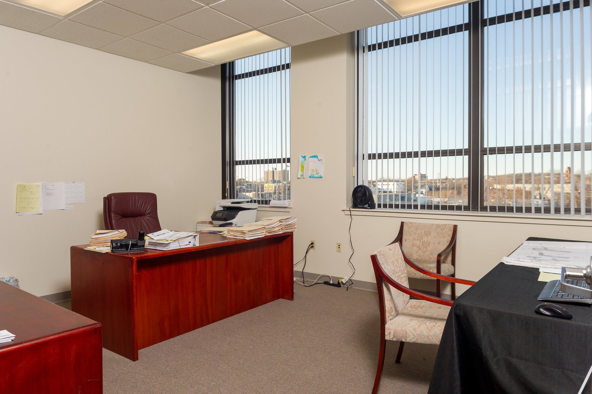 A small office with a desk , chair , and window.