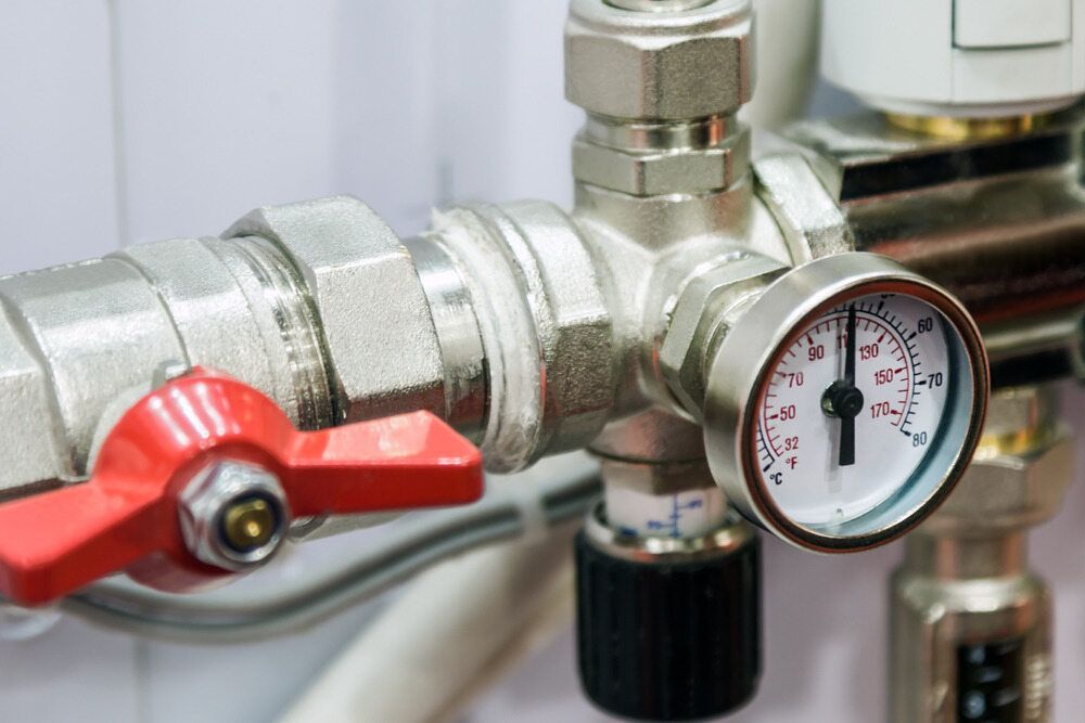 Close-Up of A Silver Pipe System with A Red Valve and A Pressure Gauge — FNQ Footprints Plumbing In Whitfield, QLD