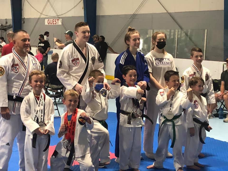 A group of people in karate uniforms are posing for a picture.