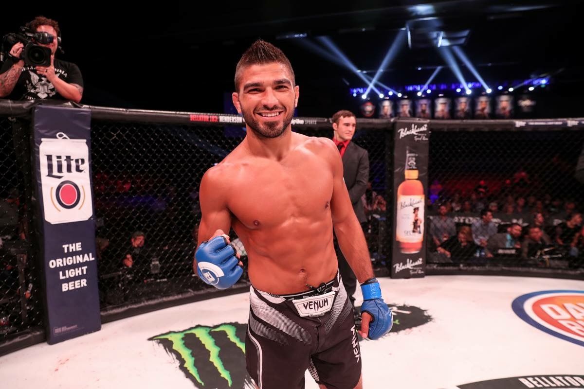 A man is standing in a boxing ring with a monster energy drink in the background.