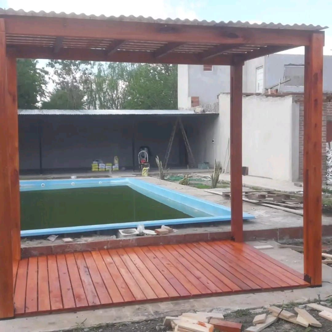 Pérgola de madera con deck junto a piscina, teñida en marrón.