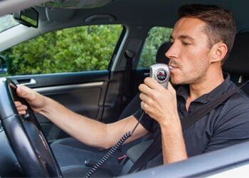 DUI Attorney — Man Blowing into Breathalyzer in Miamisburg, OH