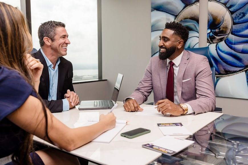 A group of people are sitting around a table having a meeting.