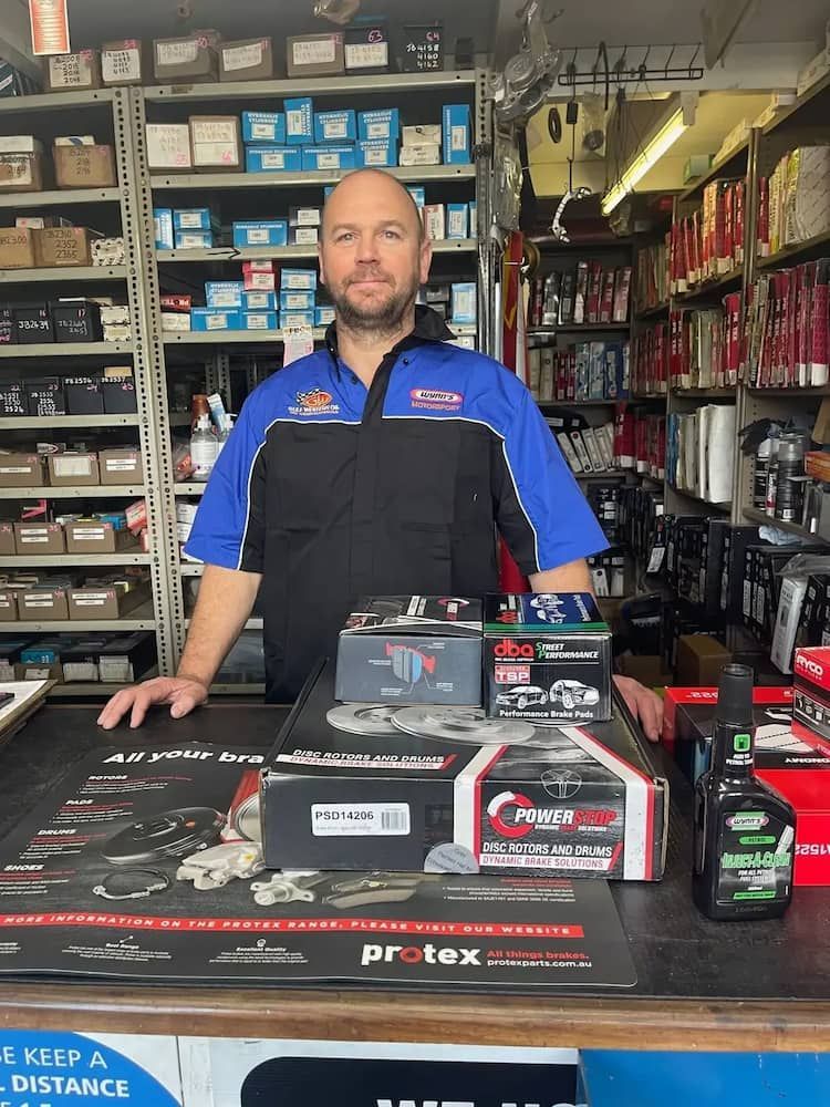 A Man Is Standing In Front Of A Counter In A Store — Figtree Brake & Clutch Services in Figtree, NSW