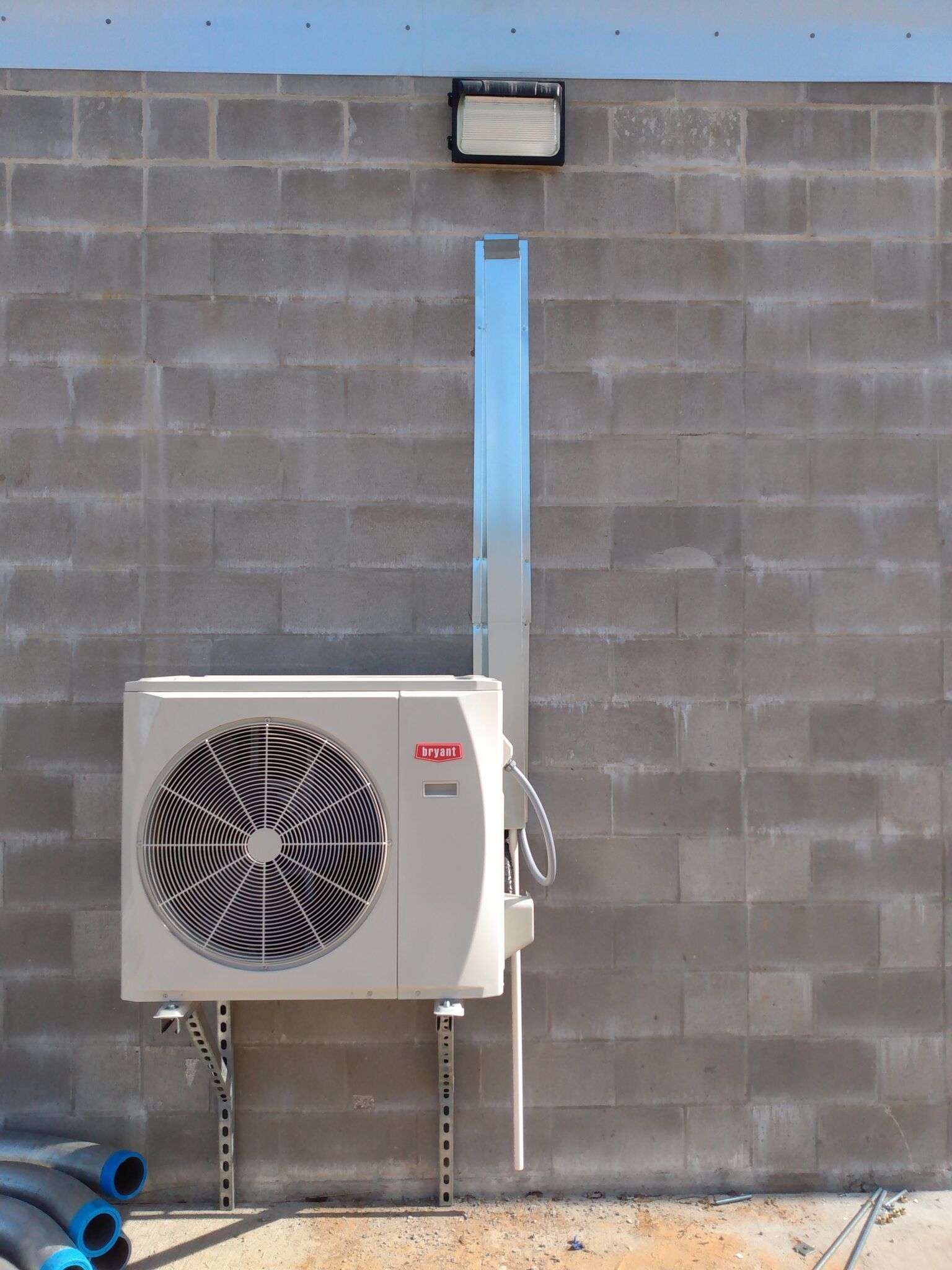 An air conditioner is mounted to a brick wall