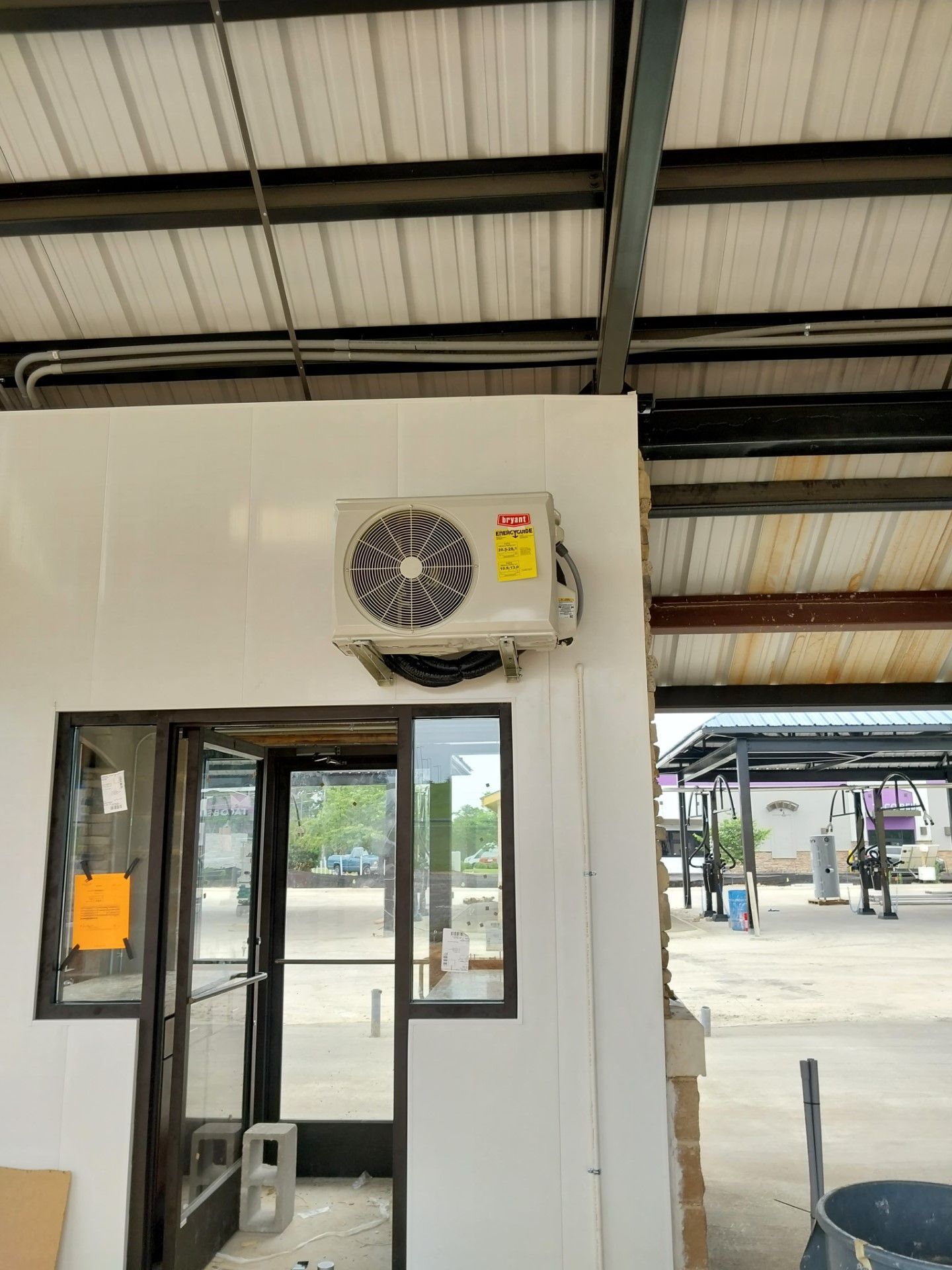 A fan is hanging from the ceiling of a building next to a door.