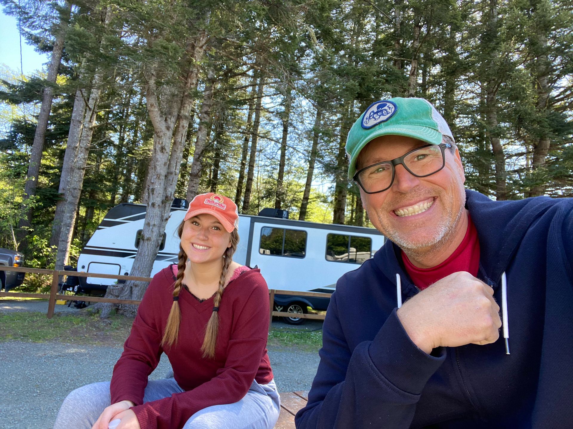 John and Madison are sitting next to each other in front of a RV in Redwood National Park.
