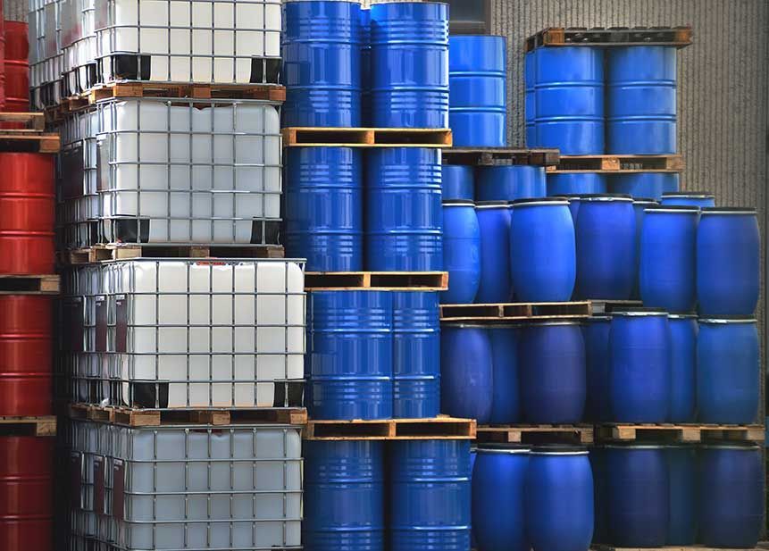 A bunch of barrels are stacked on top of each other on pallets.