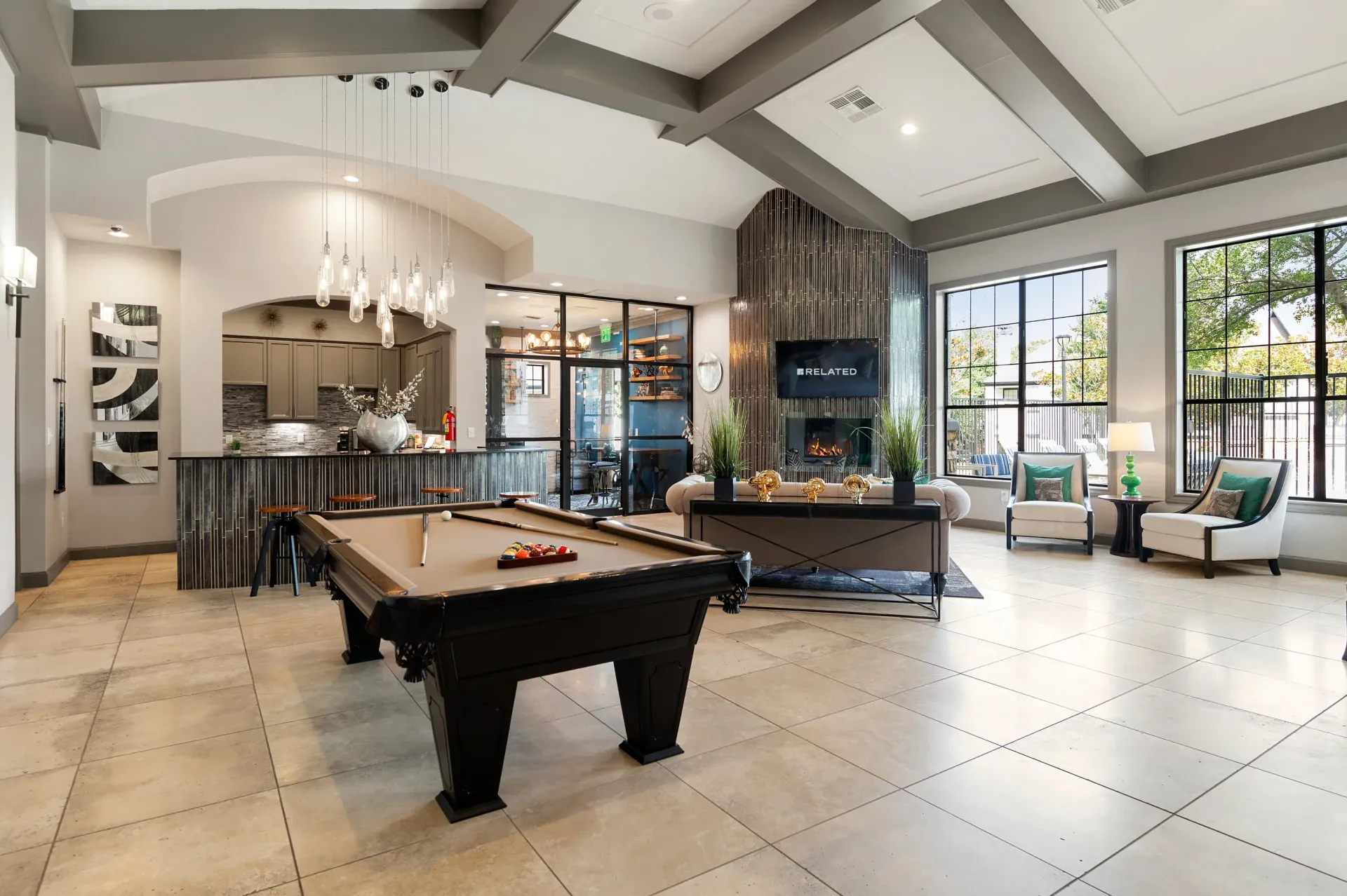 Interior photo of a community lounge with a pool table and seating areas at Villas of Vista Ridge in Lewisville, TX.