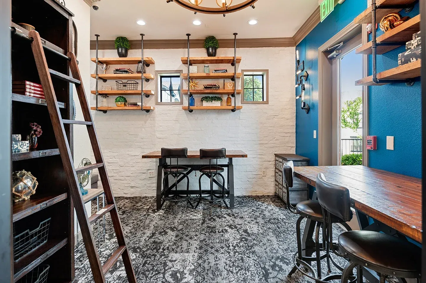 Cozy community lounge area with wooden shelving and tables at Villas of Vista Ridge in Lewisville, TX.