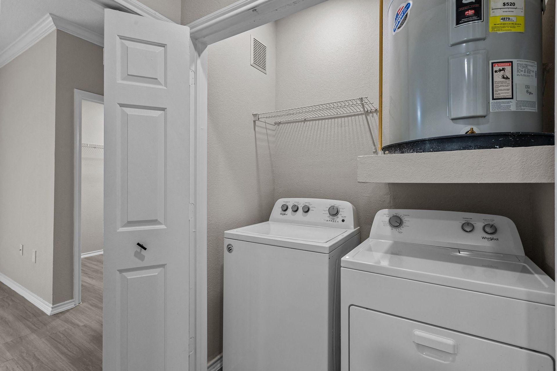 Laundry area featuring a washing machine and a dryer in a residential unit at Villas of Vista Ridge in Lewisville, TX.