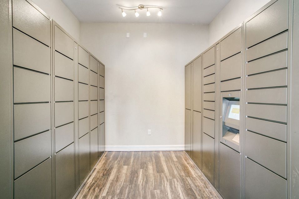 Interior view of a mailroom with grey lockers at Villas of Vista Ridge in Lewisville, TX.