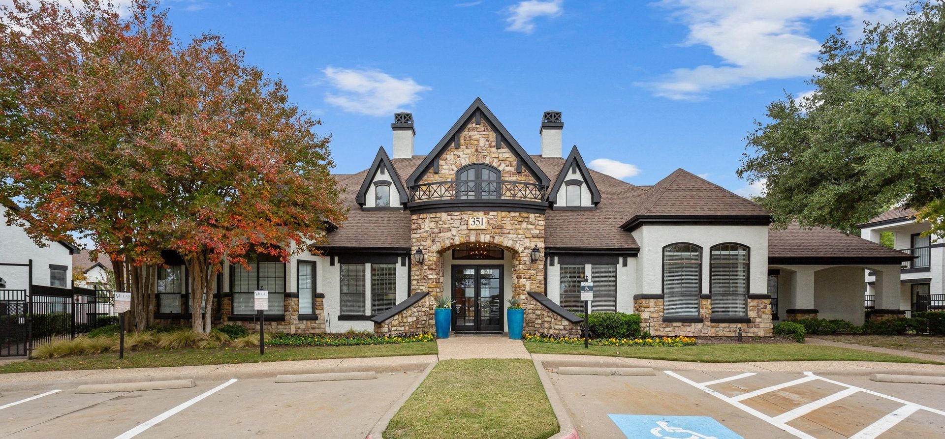 Exterior view of a property building with a landscaped entrance at Villas of Vista Ridge in Lewisville, TX.