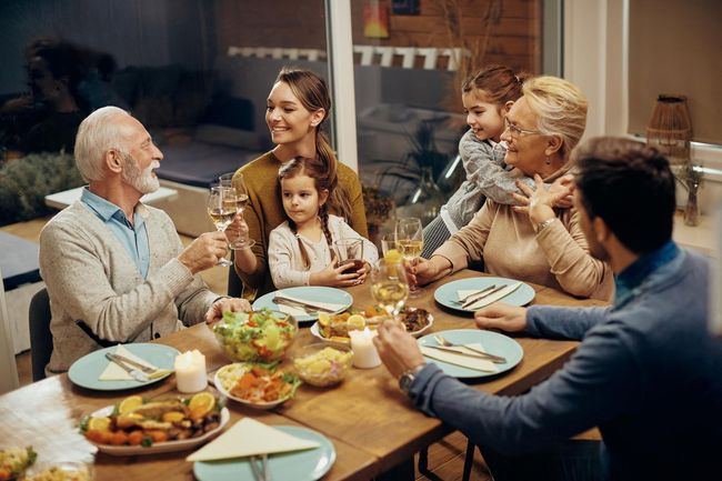 A family is sitting at a table for a thanksgiving dinner.
