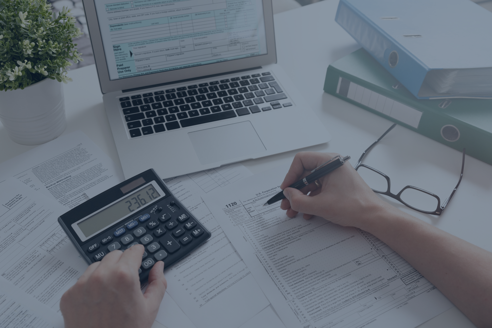 A person is using a calculator and writing on a piece of paper.