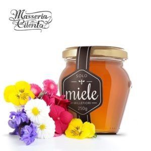 Un barattolo di miele solo accanto ad alcuni fiori