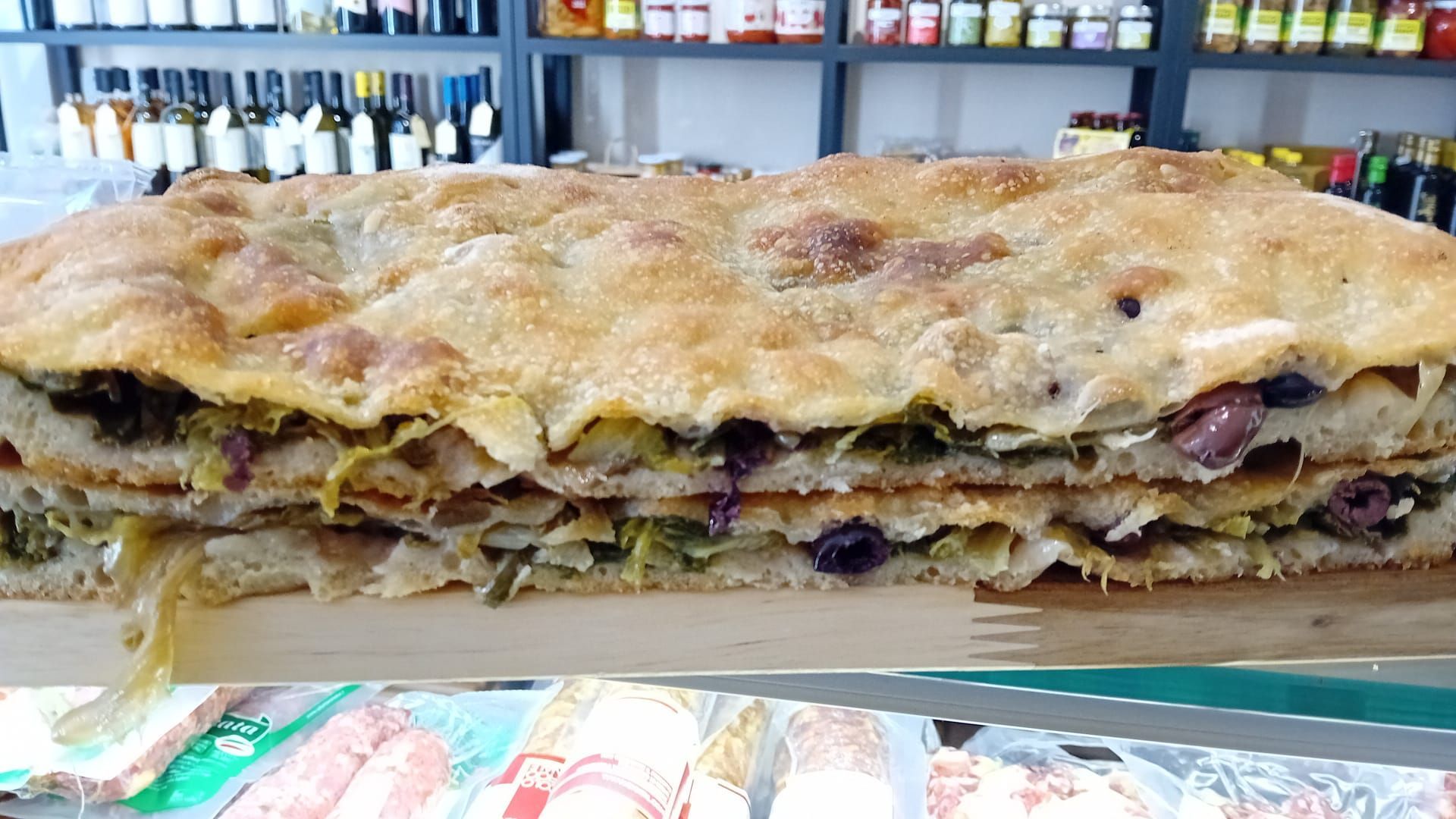 Un panino molto lungo è appoggiato su un tagliere di legno