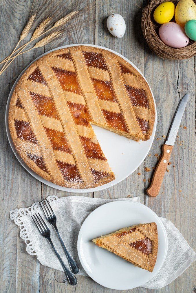Una torta da cui è stata tolta una fetta è su un piatto su un tavolo di legno.