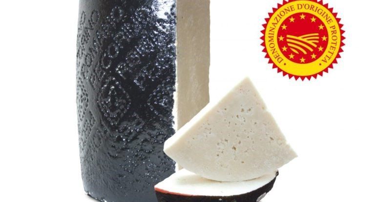 Un pezzo di formaggio è appoggiato accanto a una bottiglia di vino