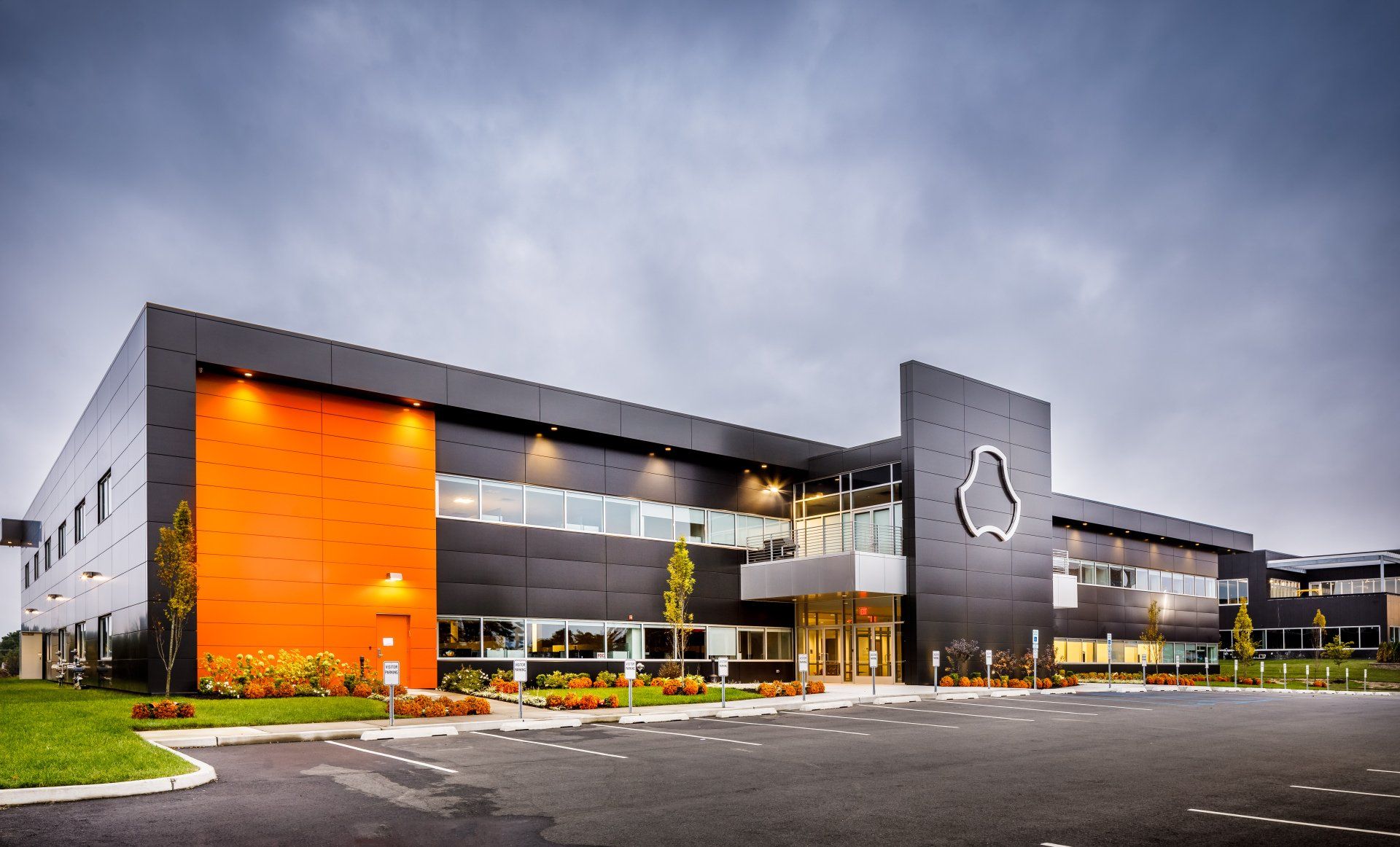 A large black and orange building with a logo on the side of it.