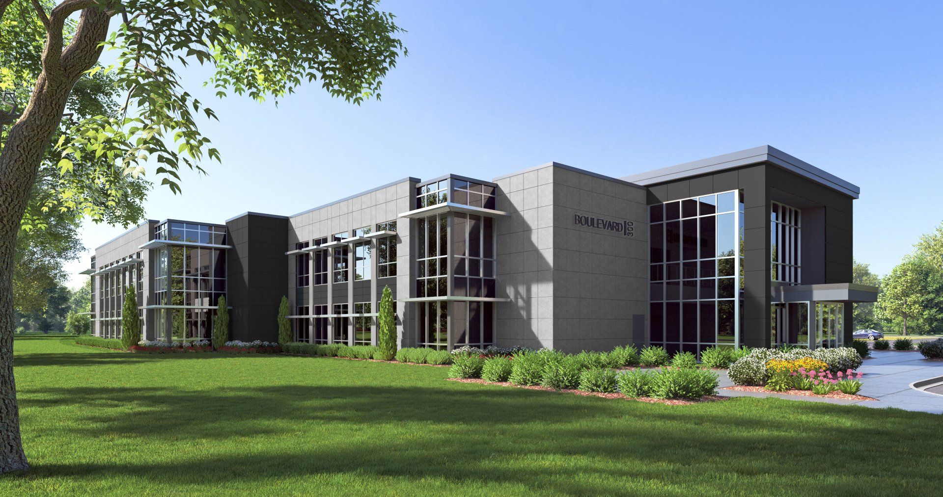 A large building with a lot of windows is surrounded by grass and trees.