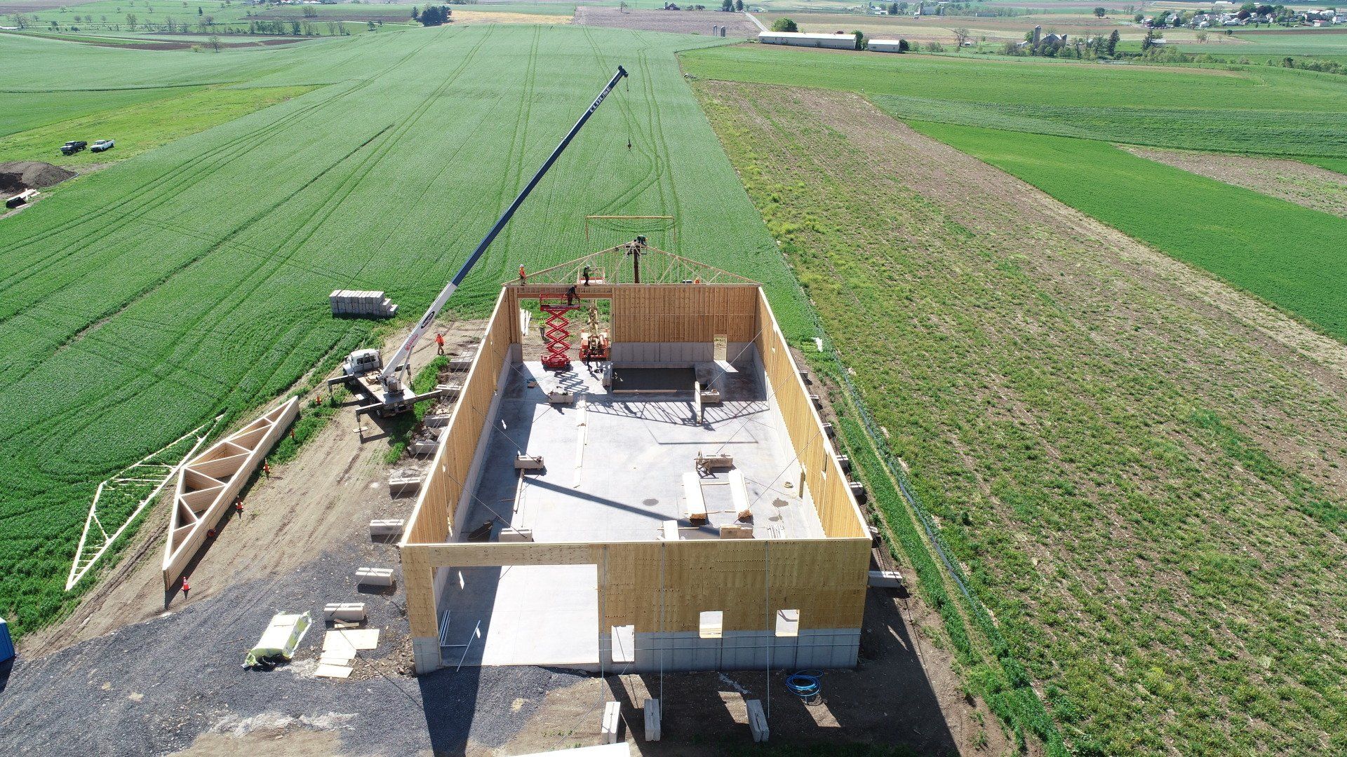 An aerial view of a building under construction in a field.
