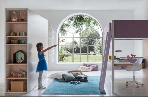 bambina gioca di fronte a letto a castello