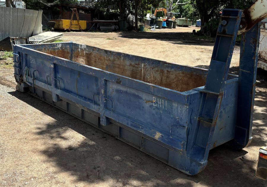 A Yellow Dumpster Is Sitting In Front Of A Brick House — Bin Hire In Maryborough, QLD
