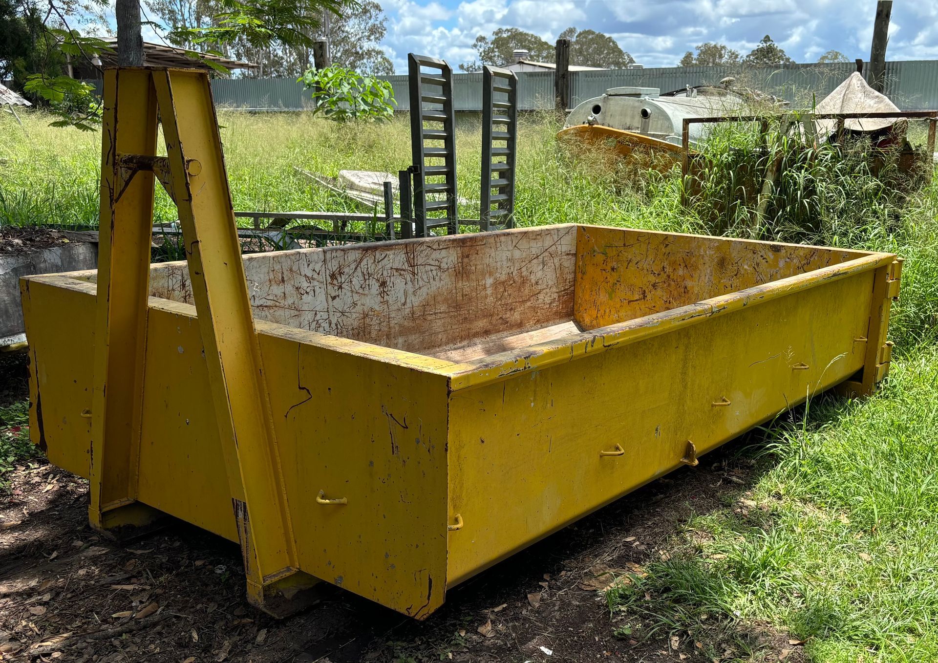 A Yellow Skip Bin Surrounded By Grass — Bin Hire in Maryborough, QLD