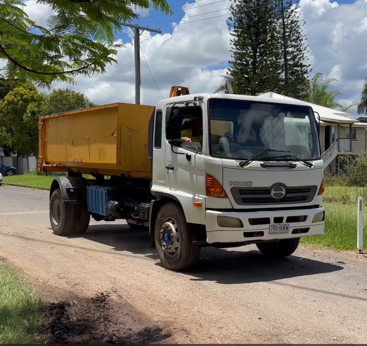 A White Dump Truck is Parked on the Side of the Road — Bin Hire in Maryborough, QLD