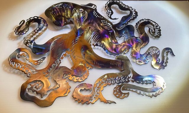 A metal octopus is sitting on a white surface
