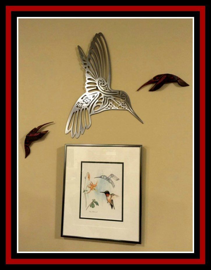 a framed picture of a hummingbird is hanging on a wall