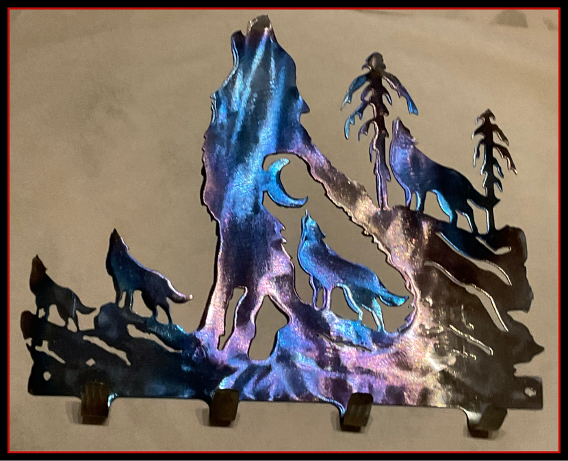 a metal sculpture of wolves howling at the moon with key hooks
