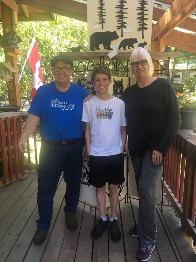 a boy wearing a brooklyn levi 's shirt poses for a picture with his parents