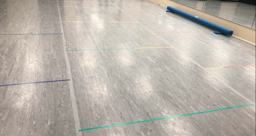 A gray floor with green lines on it in a gym.