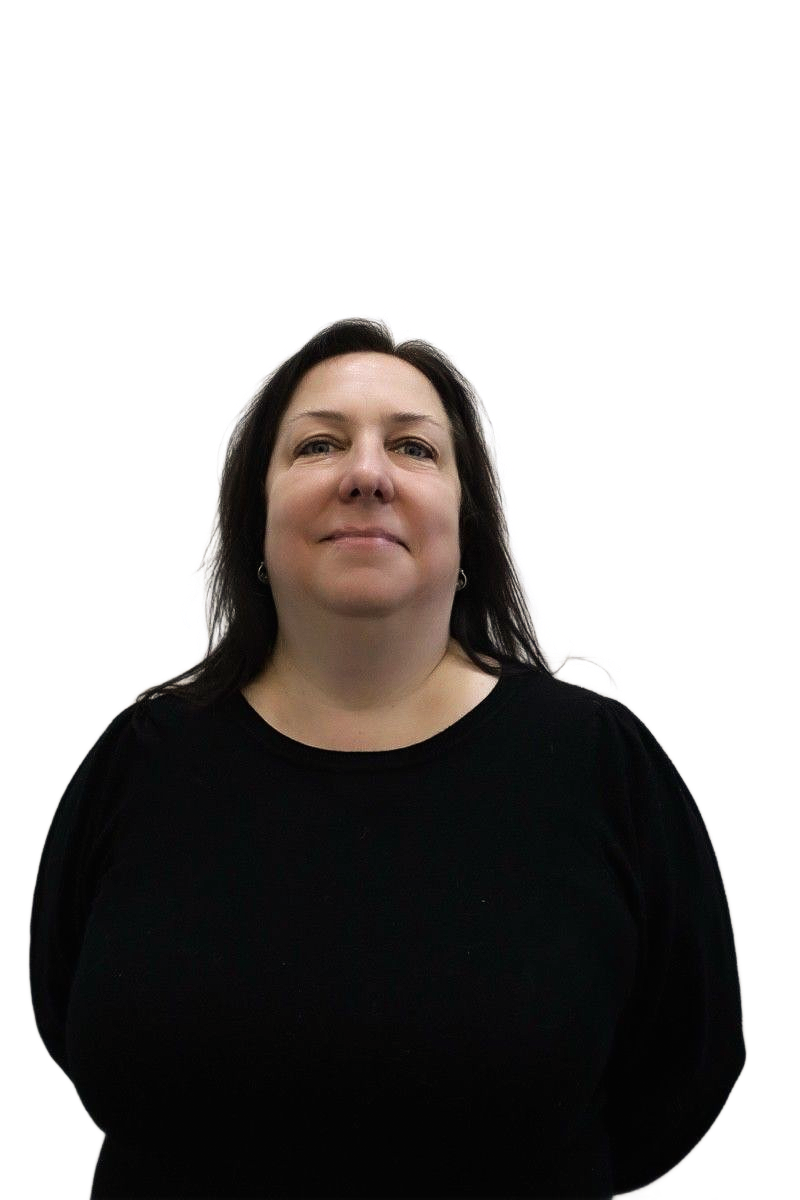 Woman in black sweater, looking upwards with a slight smile, against a white wall.