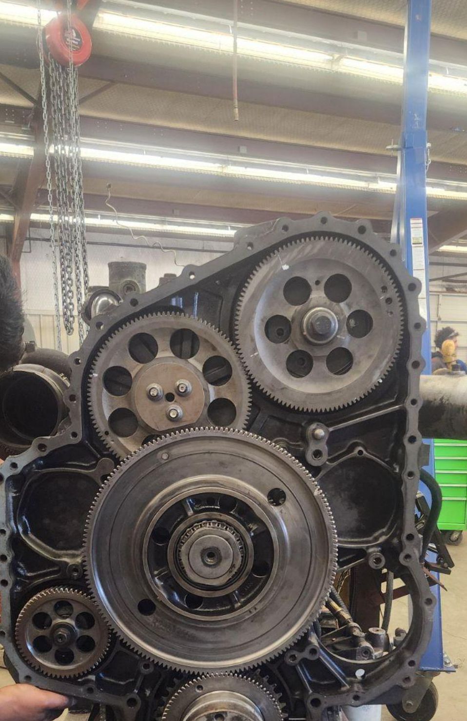 A person is working on a large engine in a garage.