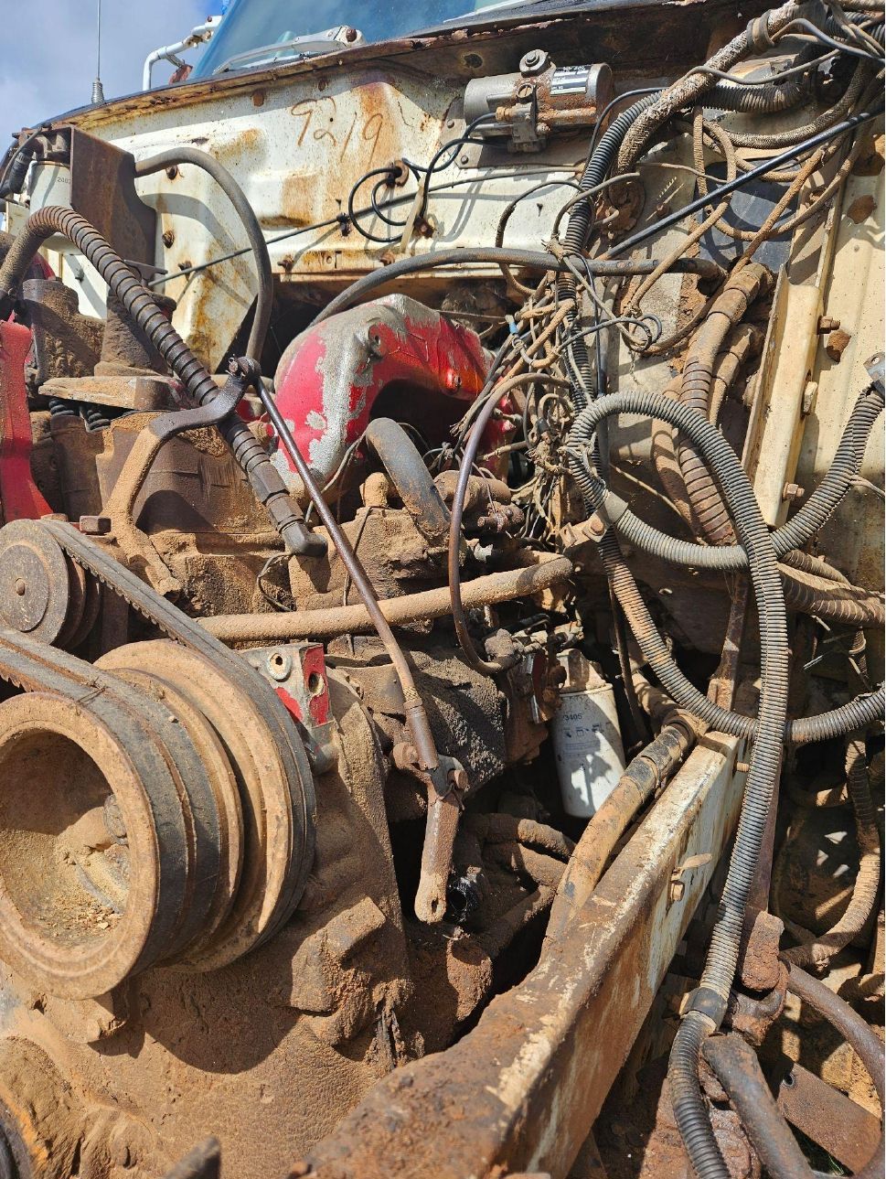 A close up of a car engine with a lot of wires coming out of it.