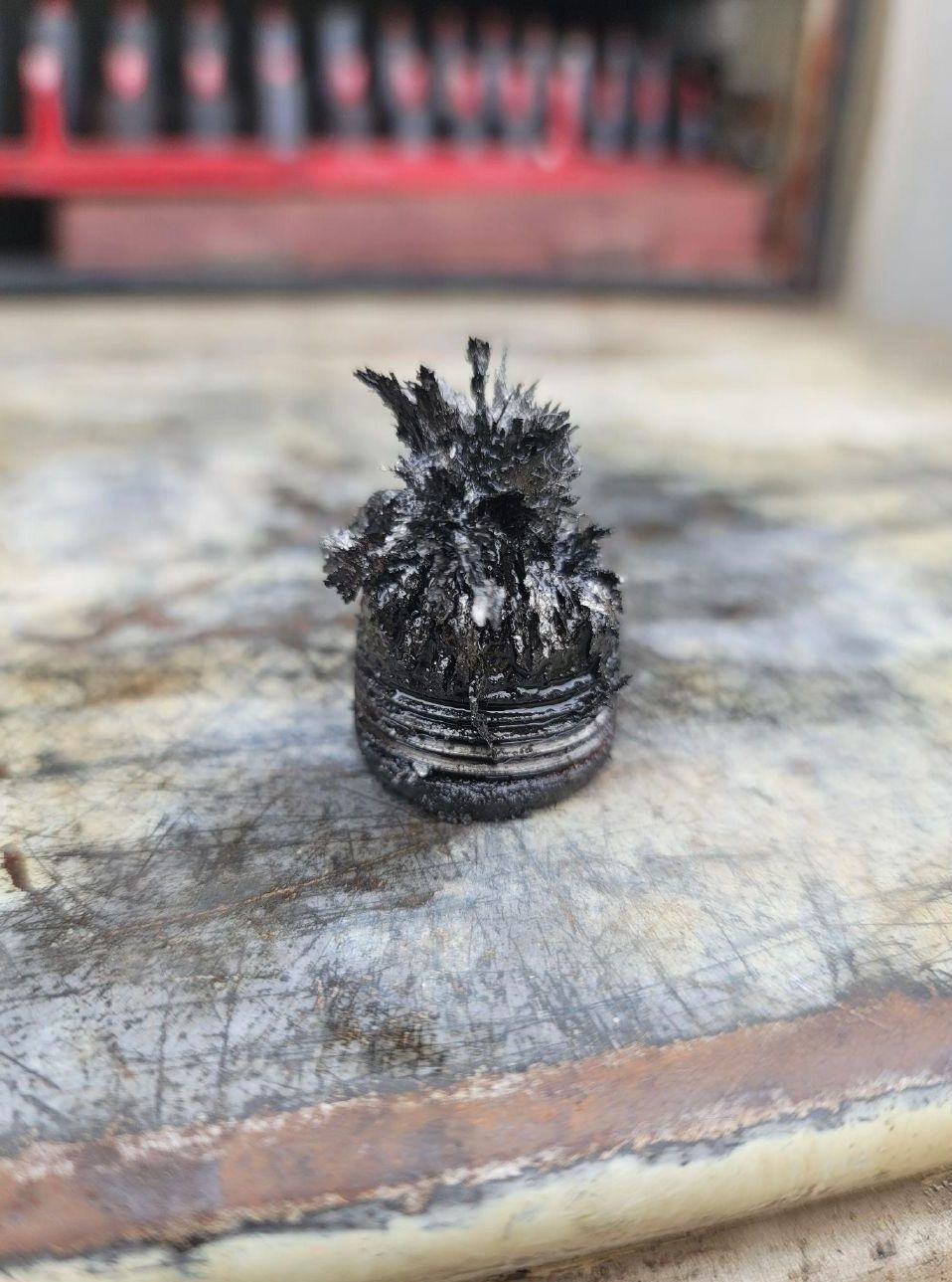 A small piece of metal is sitting on a wooden table.