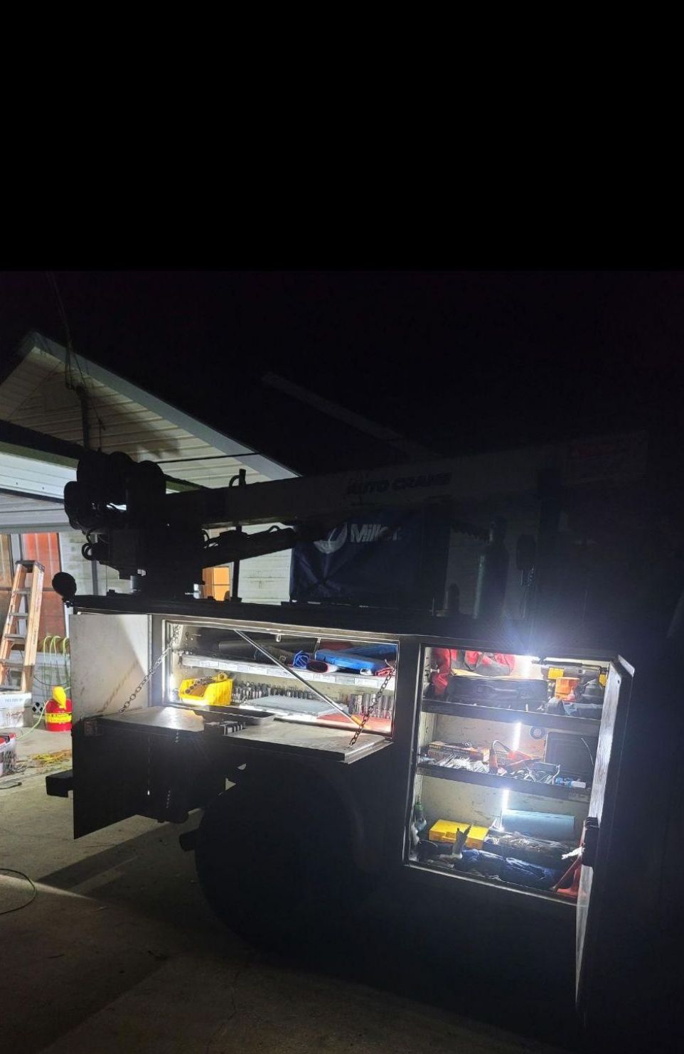 A food truck is parked in a garage at night.