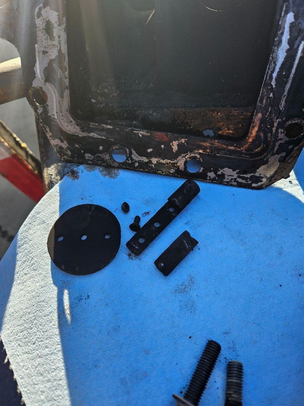 A piece of metal is laying on a blue surface