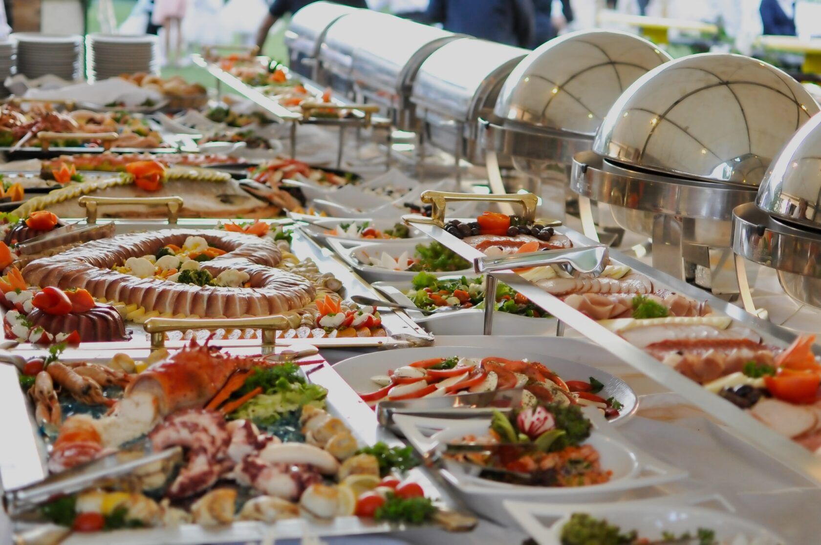 A buffet table filled with lots of food and plates of food.