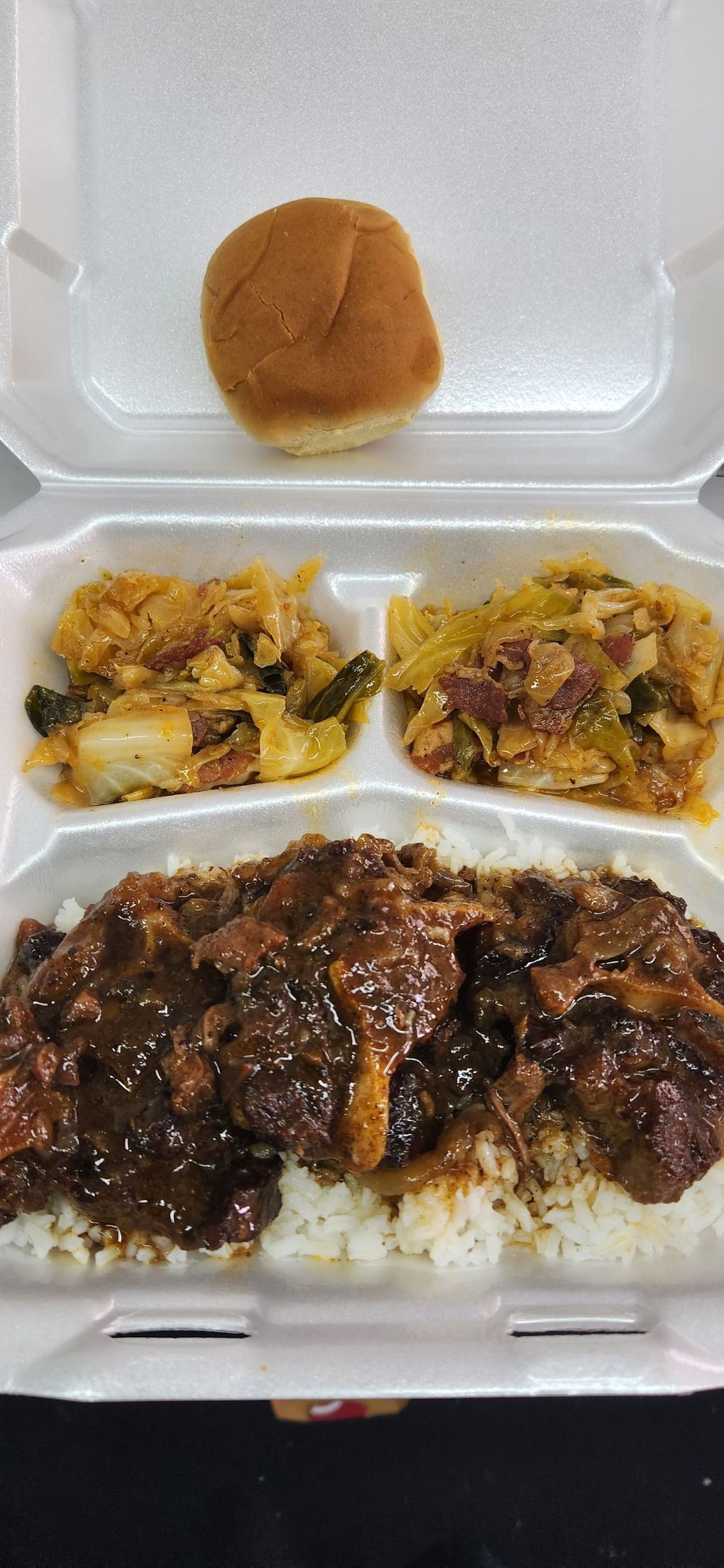 A styrofoam container filled with rice , meat , and vegetables.