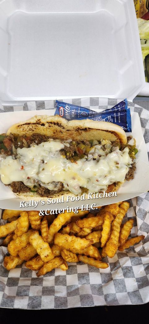 A steak sandwich and french fries in a styrofoam container.