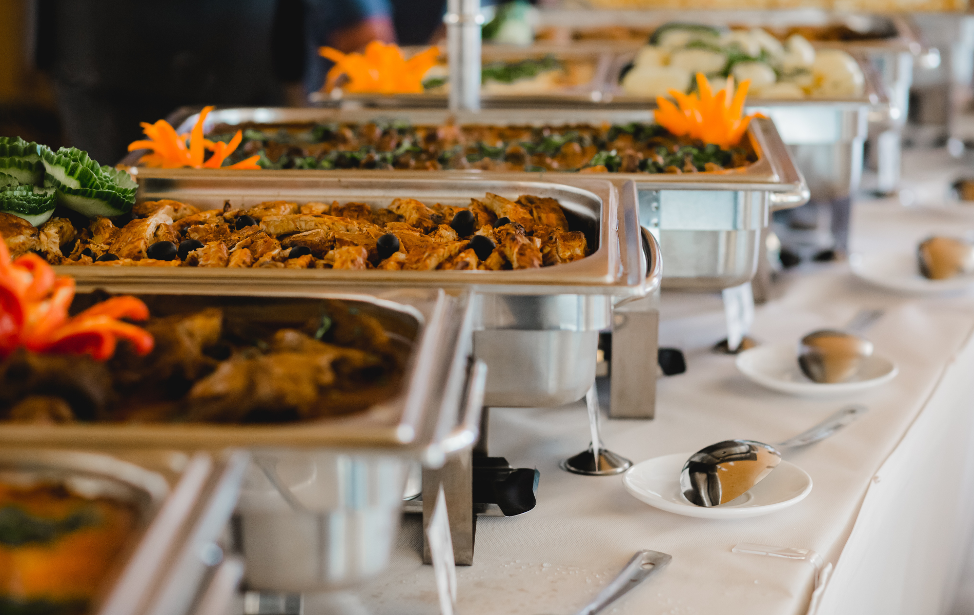 There are many trays of food on the table.