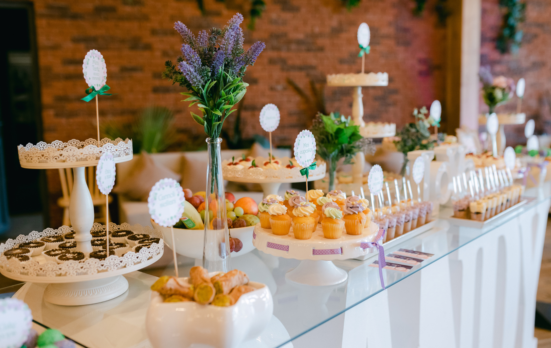 A buffet table with a variety of desserts and flowers on it.