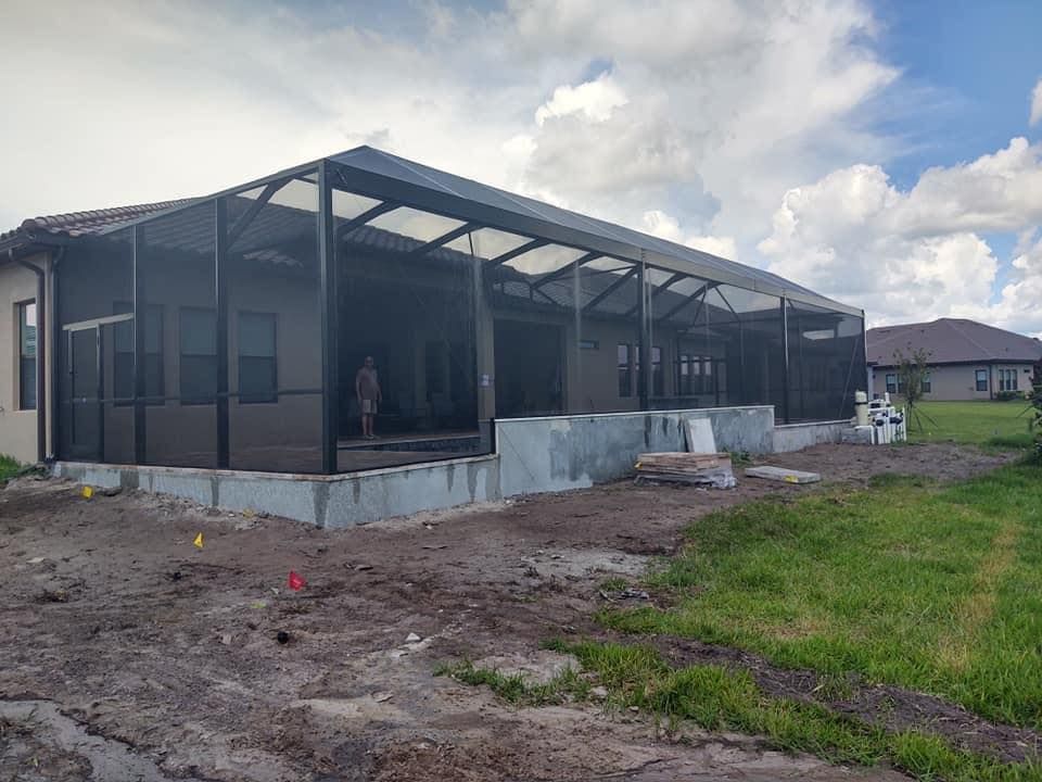 A screened in porch is being built on the back of a house.