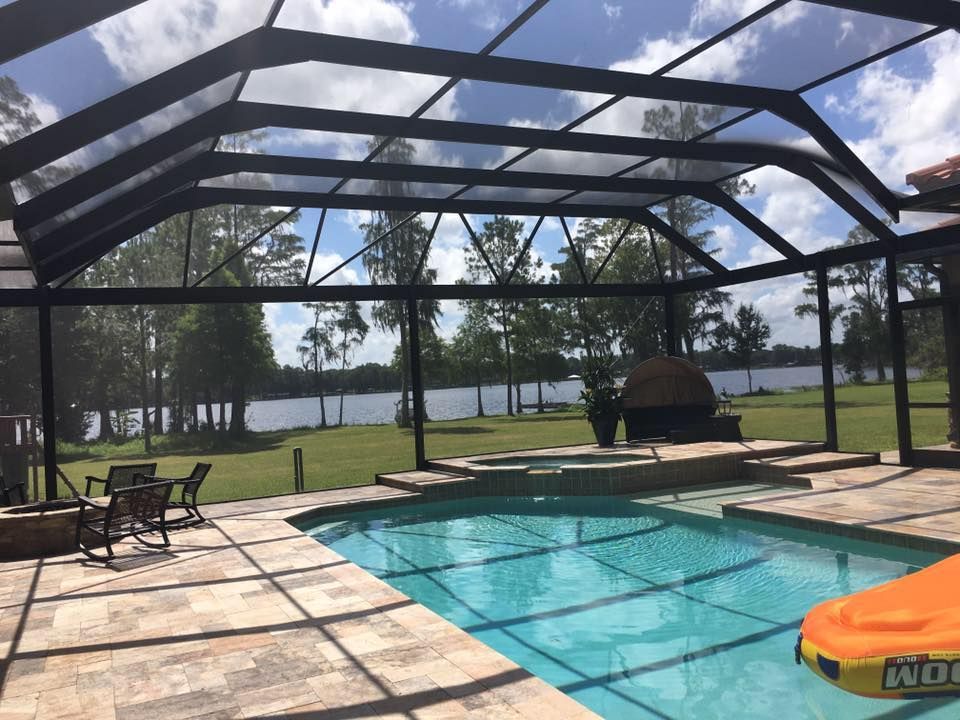 A swimming pool with a screened in area and a raft in the water.