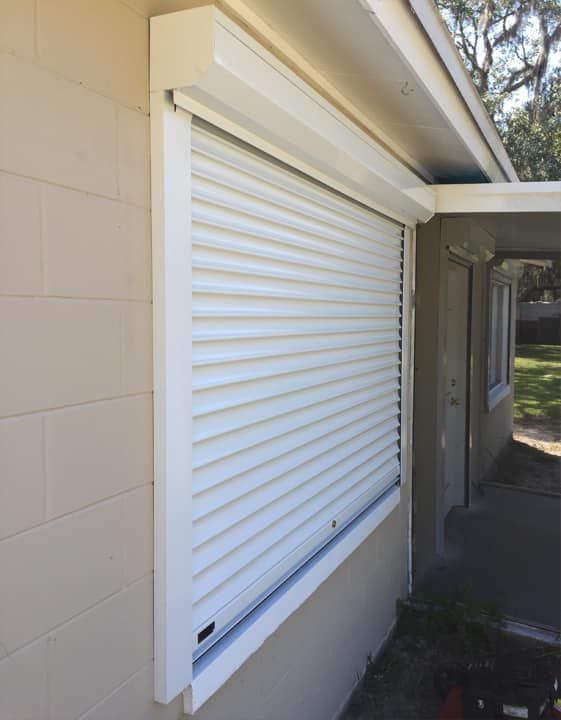 A white window with a roller shutter on it