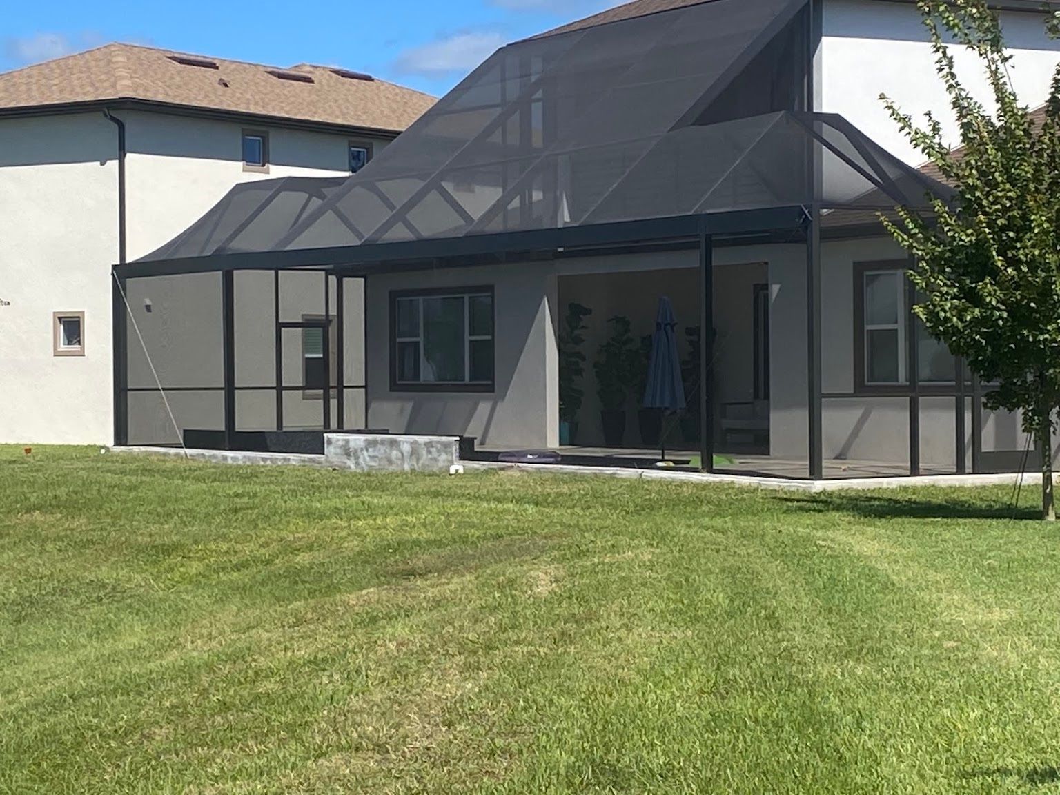 A house with a screened in porch in the backyard